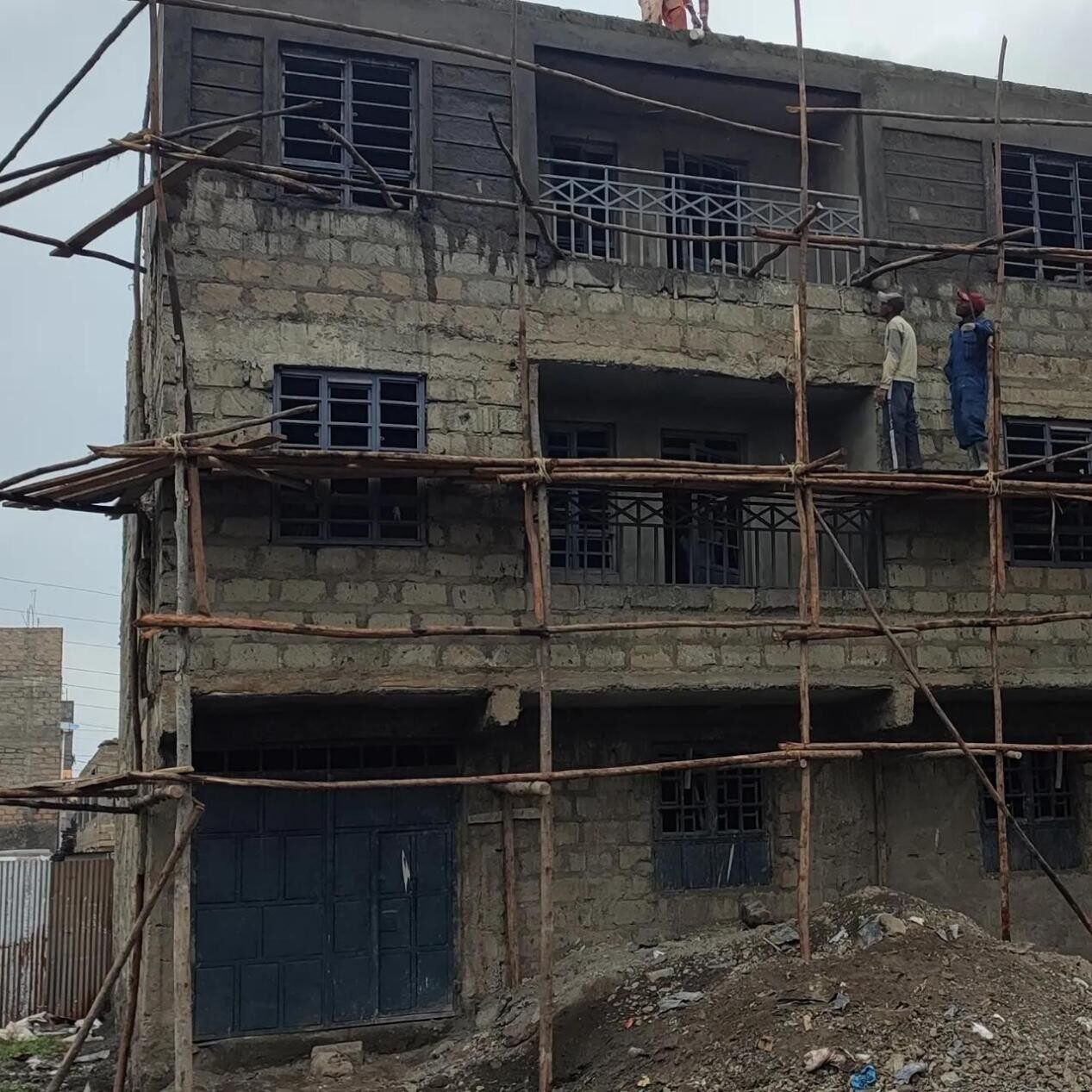 Umoja apartments under construction with timber scaffolding and workers