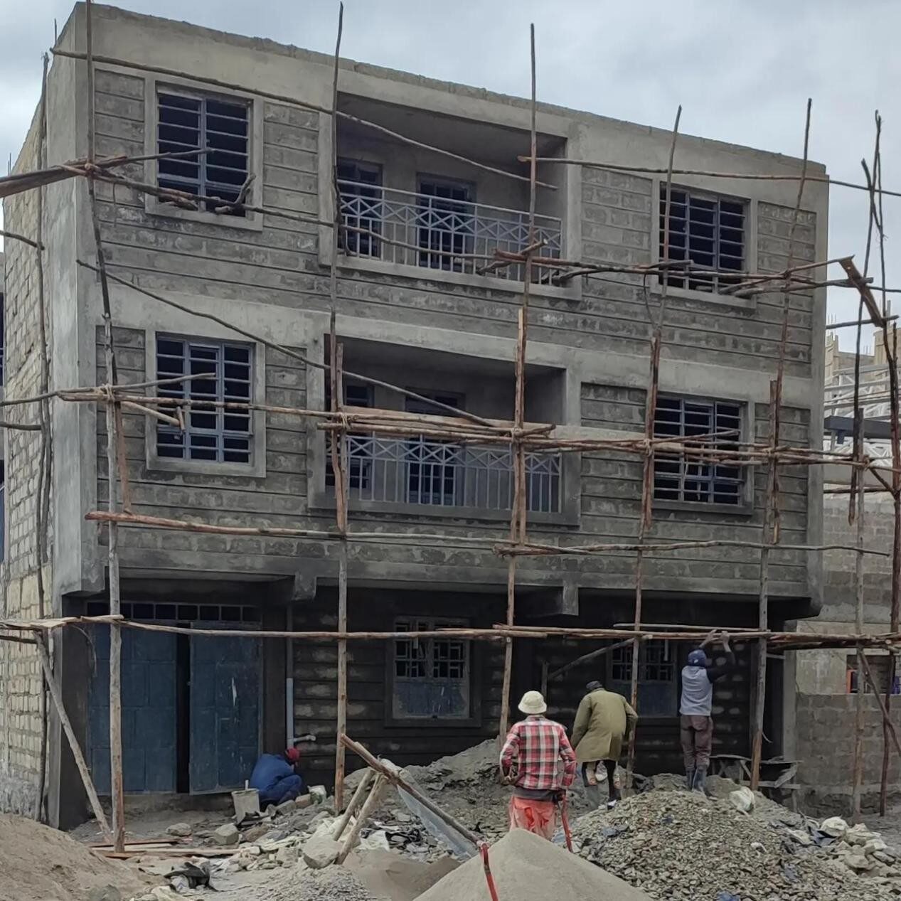 Construction workers on scaffolding at the Umoja apartments site