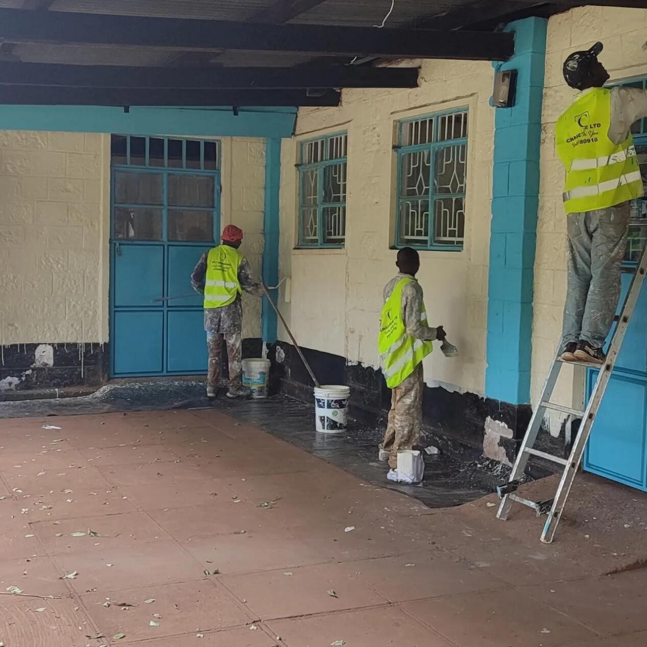 Three Chaschase workers repainting a University of Nairobi building